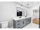 Bathroom featuring a double vanity with gray cabinets, black hardware, and modern pendant lighting at 1798 Braselton Hwy, Lawrenceville, GA 30043