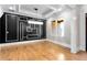 Dining room featuring hardwood floors, modern chandelier, and a black accent wall with white trim design at 1798 Braselton Hwy, Lawrenceville, GA 30043