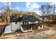 A classic two-story home with a well-manicured lawn and dark roof, surrounded by mature trees and greenery at 1798 Braselton Hwy, Lawrenceville, GA 30043