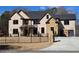 Two-story brick home with black trim, black metal fence, stone accents, a black roof and two-car garage at 1798 Braselton Hwy, Lawrenceville, GA 30043