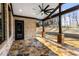Covered outdoor patio featuring stone flooring, brick columns, a ceiling fan, and an exterior view at 1798 Braselton Hwy, Lawrenceville, GA 30043