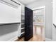 Walk-in closet featuring custom shelving, black hardware, and hardwood floors leading to the bedroom at 1798 Braselton Hwy, Lawrenceville, GA 30043