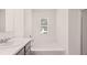 Bright bathroom with a large mirror, sink, and bathtub at 8590 Secretariat Dr, Lithonia, GA 30058