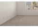 A freshly carpeted room featuring light colored walls and a window with neighborhood views at 8590 Secretariat Dr, Lithonia, GA 30058
