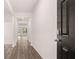 Bright hallway with hardwood floors and a stylish, dark-toned front door at 8590 Secretariat Dr, Lithonia, GA 30058