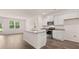 Modern kitchen with white cabinets, stainless steel appliances, a granite island, and hardwood floors at 8590 Secretariat Dr, Lithonia, GA 30058