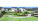 Community playground with slides and climbing structures, surrounded by a black metal fence, walking paths, and lush landscaping at 8590 Secretariat Dr, Lithonia, GA 30058