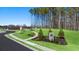 Landscaped entry to Champions Run neighborhood with sidewalk and green space at 8590 Secretariat Dr, Lithonia, GA 30058