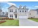 Beautiful two-story white brick home featuring an attached garage, manicured lawn, and charming curb appeal at 6096 Marigold Way, Atlanta, GA 30349