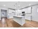 Bright kitchen featuring white cabinetry, an island with a sink, stainless steel appliances and hardwood floors at 6096 Marigold Way, Atlanta, GA 30349