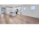 Open-concept living space with hardwood floors seamlessly connecting to a kitchen with an island and stainless appliances at 6096 Marigold Way, Atlanta, GA 30349