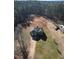 Aerial view of gray home surrounded by lawn and woods at 1004 Hamilton Dr, Locust Grove, GA 30248