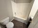 Bathroom featuring a tub with shower head and a toilet at 1004 Hamilton Dr, Locust Grove, GA 30248