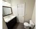 Bathroom with a single sink vanity, wood-look flooring, and a toilet at 1004 Hamilton Dr, Locust Grove, GA 30248