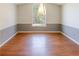 Formal dining room featuring hardwood floors, wainscoting, and a large window at 1004 Hamilton Dr, Locust Grove, GA 30248