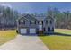 Charming two-story home with a two-car garage and a well-manicured lawn surrounded by mature trees at 1004 Hamilton Dr, Locust Grove, GA 30248
