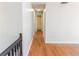 Upstairs hallway with hardwood floors, neutral paint, and access to multiple rooms at 1004 Hamilton Dr, Locust Grove, GA 30248