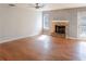Bright and airy living room featuring hardwood floors, a brick fireplace, and a door to the outside at 1004 Hamilton Dr, Locust Grove, GA 30248