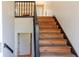 Staircase with wooden steps, dark railing, and a view of the lower level and an upstairs window at 1004 Hamilton Dr, Locust Grove, GA 30248