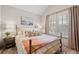 Cozy bedroom with shiplap wall, plantation shutters, iron bedframe, and designer decor at 203 Hubbard Rd, Woodstock, GA 30188