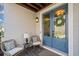 Inviting porch area featuring stylish wicker chairs and a charming double door entrance with decorative wreaths at 203 Hubbard Rd, Woodstock, GA 30188