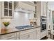 White cabinets, stainless steel appliances and a range hood in this well-equipped kitchen at 203 Hubbard Rd, Woodstock, GA 30188