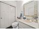 Stylish powder room with decorative mirror, modern vanity, and convenient toilet closet at 203 Hubbard Rd, Woodstock, GA 30188