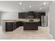 Kitchen with dark wood cabinetry, an island, stainless steel appliances, and granite countertops at 5253 Rosewood Pl, Fairburn, GA 30213
