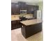 Kitchen with dark cabinets, stainless steel appliances, and a granite island at 5253 Rosewood Pl, Fairburn, GA 30213