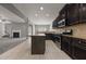 Modern kitchen featuring dark cabinets, tile floors, stainless appliances, and stone countertops at 5253 Rosewood Pl, Fairburn, GA 30213