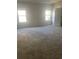 Spacious main bedroom with neutral carpet, two windows, and a paneled door at 5253 Rosewood Pl, Fairburn, GA 30213