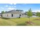 Backyard view of a home with a well-maintained lawn and young trees under a blue sky with scattered clouds at 8603 Secretariat Dr, Lithonia, GA 30058
