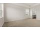 Bedroom featuring tray ceiling, carpet flooring, and natural light with attached bathroom at 8603 Secretariat Dr, Lithonia, GA 30058