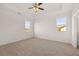 A spacious carpeted bedroom with a ceiling fan and natural light from two windows at 8603 Secretariat Dr, Lithonia, GA 30058
