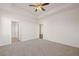 Spacious main bedroom featuring neutral carpeting, ceiling fan, and access to ensuite bath at 8603 Secretariat Dr, Lithonia, GA 30058