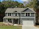 Two-story home with gray siding, shuttered windows, a covered porch, and a two-car garage at 1114 Campbell Rd, Covington, GA 30014