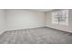 A bright bedroom features neutral walls, gray carpet, and a window with natural light at 4030 Staghorn Ct, Douglasville, GA 30135
