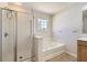 Bathroom showcasing a separate shower, tub, and a window at 4157 Medlock Woods Dr, Snellville, GA 30039