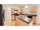 Functional kitchen with wooden cabinets, an island, dark countertops, and hardwood floors, ideal for cooking at 4157 Medlock Woods Dr, Snellville, GA 30039