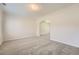 Spacious living room with neutral carpet, white walls, and an arched doorway leading to other rooms at 4157 Medlock Woods Dr, Snellville, GA 30039