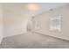 Comfortable living room with light-colored carpet, arched doorway, and ample natural light from the windows at 4157 Medlock Woods Dr, Snellville, GA 30039