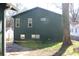 Side view of dark green siding and white windows on home with green grass at 1285 Mcclure Nw Ave, Atlanta, GA 30314