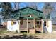 Charming renovated home featuring a quaint front porch with wood columns and railings and painted white brick at 1285 Mcclure Nw Ave, Atlanta, GA 30314