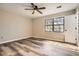Spacious bedroom featuring a ceiling fan, large window with natural light, and gray vinyl flooring at 1669 Glen Arm Dr, Lithonia, GA 30058