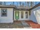 Welcoming entryway with a green front door, white brick accents, and meticulous landscaping at 1669 Glen Arm Dr, Lithonia, GA 30058