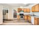 Charming kitchen features wood cabinets, stainless steel appliances, and durable gray vinyl flooring at 1669 Glen Arm Dr, Lithonia, GA 30058