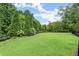 Large fenced green space with fresh sod, manicured landscaping, benches and mature trees at 220 Chastain Park Ne Dr, Atlanta, GA 30342