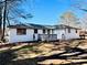 Backyard view of a charming home with a white exterior, deck, and fenced in yard at 2213 Sandtown Sw Rd, Marietta, GA 30060