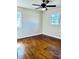 A cozy bedroom features hardwood floors, ceiling fan, and natural light from two windows at 2213 Sandtown Sw Rd, Marietta, GA 30060