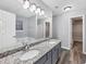 Bathroom features double sinks with granite countertops and a soaking tub beyond the mirror at 5724 Antelope Trl, Atlanta, GA 30349